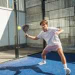 Padel Spieler mit HEAD Schläger beim Volley auf blauem Padelcourt – Sport Überbacher
