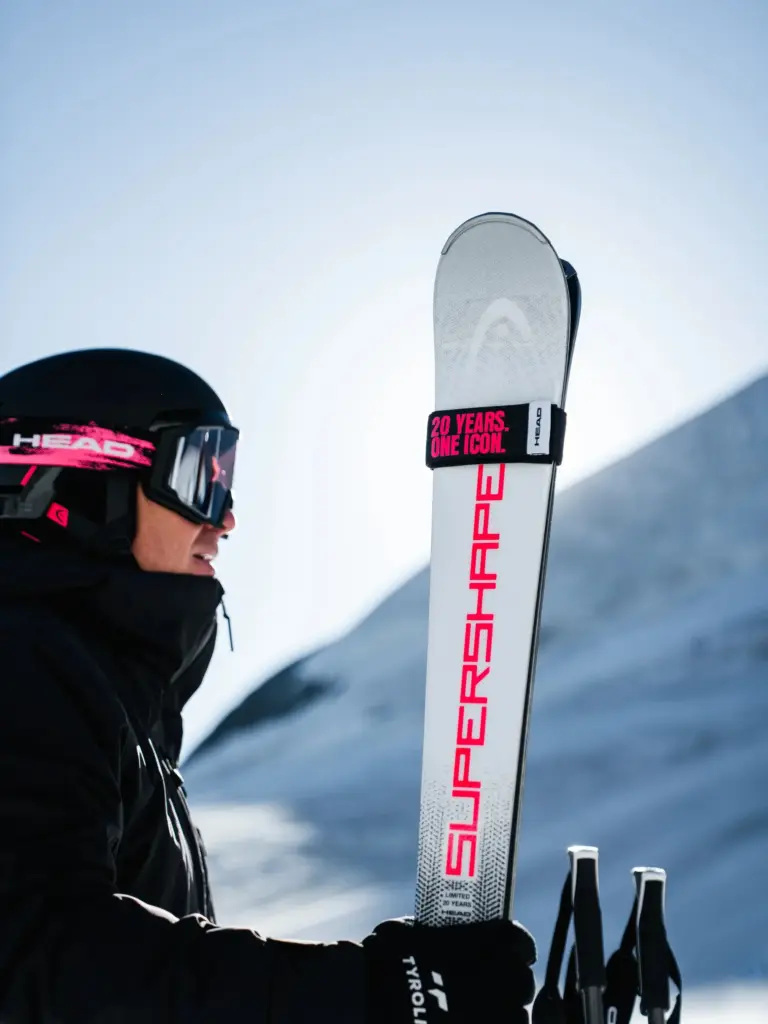 Head Supershape Limited + Protector Evo 13 GW 2026/27 Marketing-Bild, Skifahrer hält den Ski in der Hand